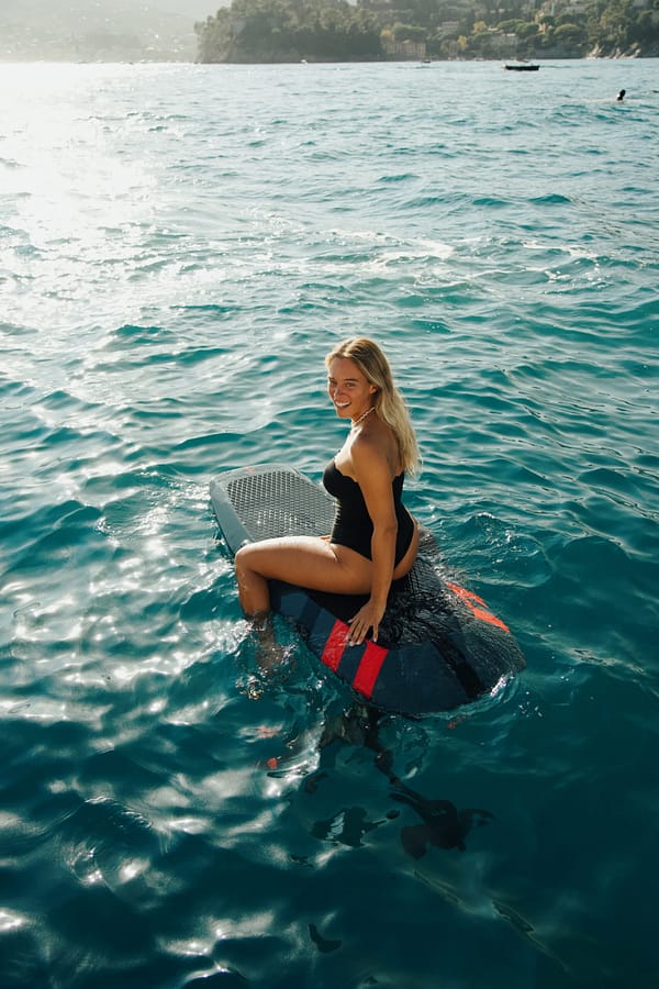 Watertoys Events BAYSIDE Watertoys Events BAYSIDE-Aerofoils-Try-and-Fly-2025-Portofino-Coast-Girl-sitting-scaled BAYSIDE Yacht Charter